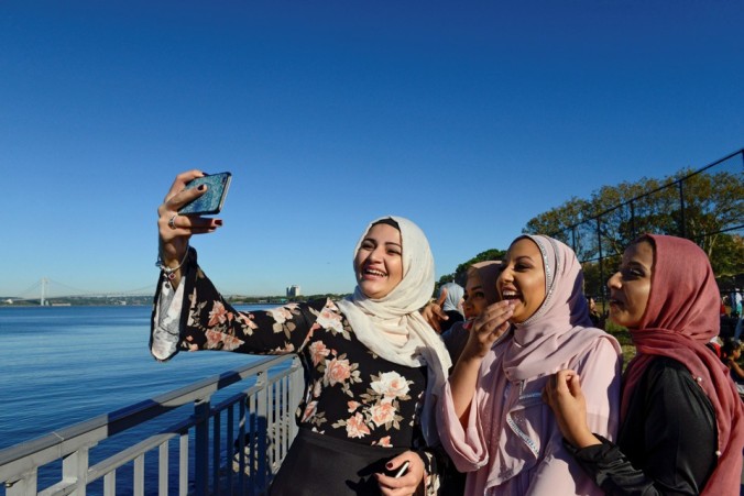 People take photos of each other before a group prayer session for the Muslim holiday Eid al-Adha in the Brooklyn borough of New York City